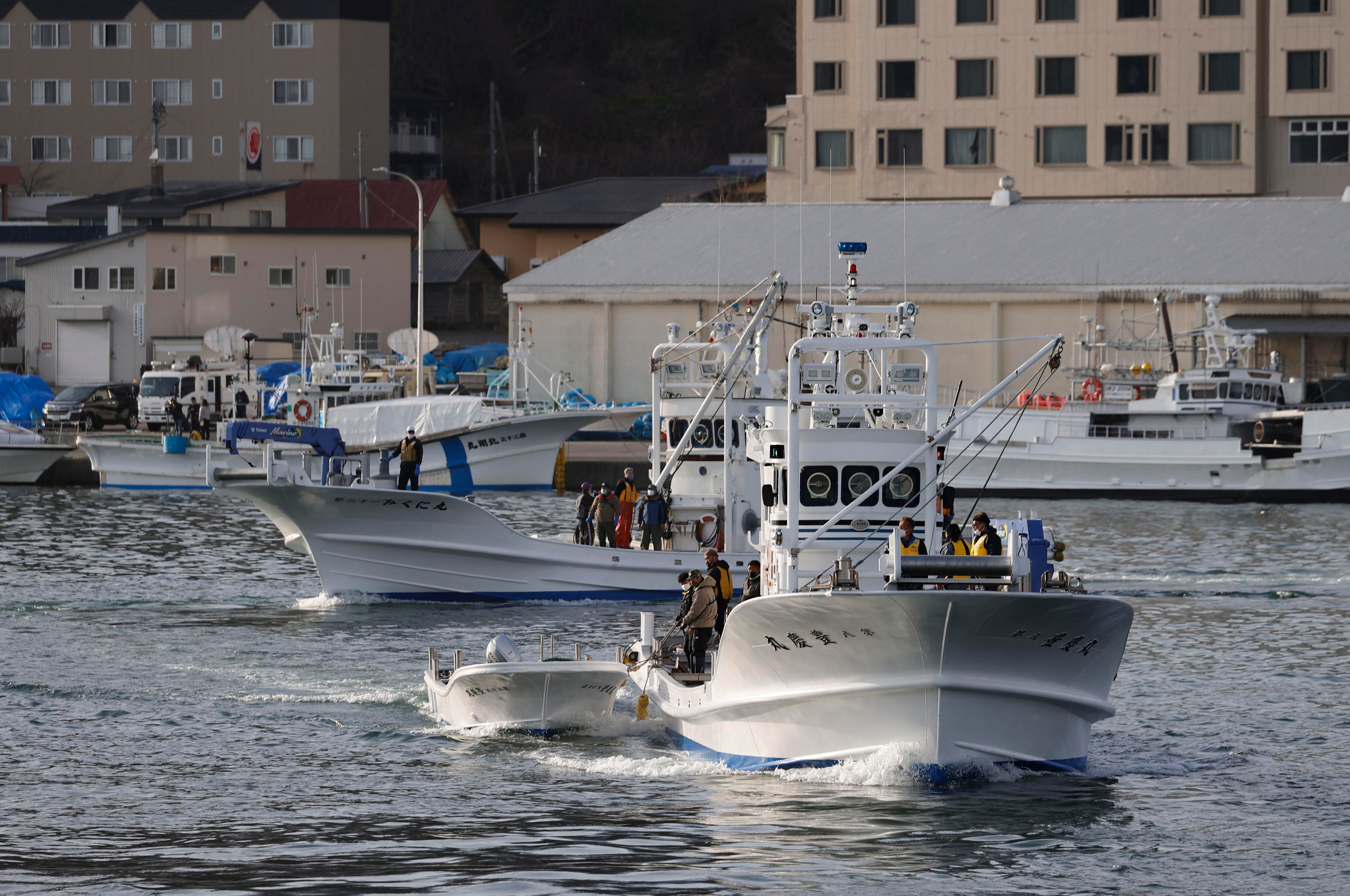 Fishing boats leave a port.