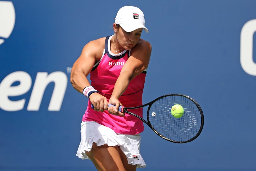 Ash Barty plays a double-handed back hand and watches the ball hit her racquet