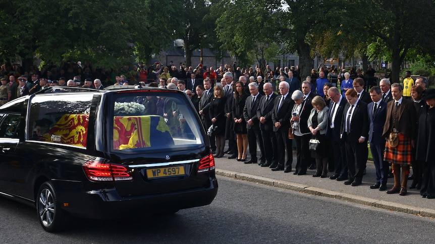 Mourners line the streets as the Queen's hearse drives by 