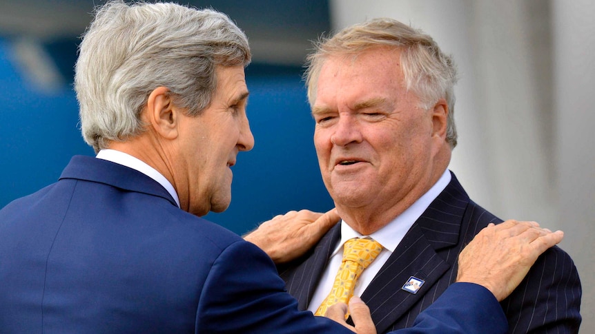 US Secretary of State John Kerry puts his hands on the shoulders of Australia's ex-Ambassador to the US Kim Beazley.