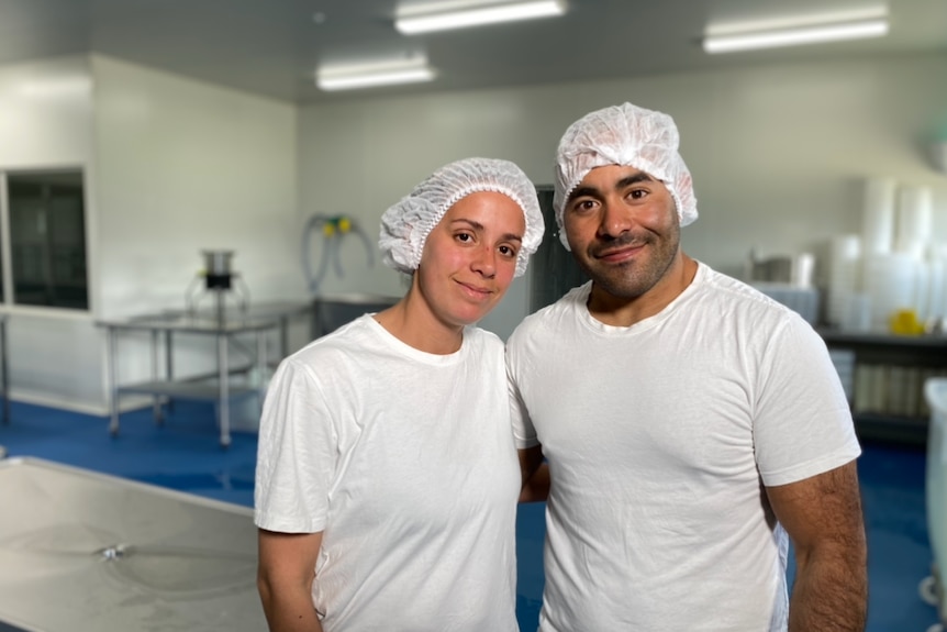 Smithton cheesemakers Rosselyn and Genaro Velasquez dressed in white with hairnets at the cheese factory.