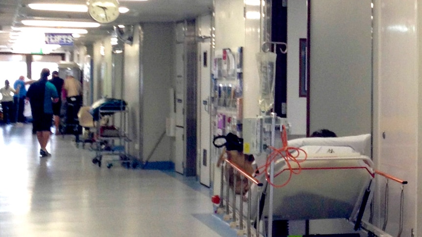 A patient in a Perth hospital bed in a corridor