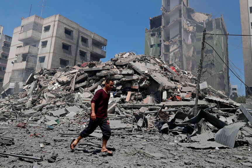 Man walks past the rubble of a destroyed building in Gaza 