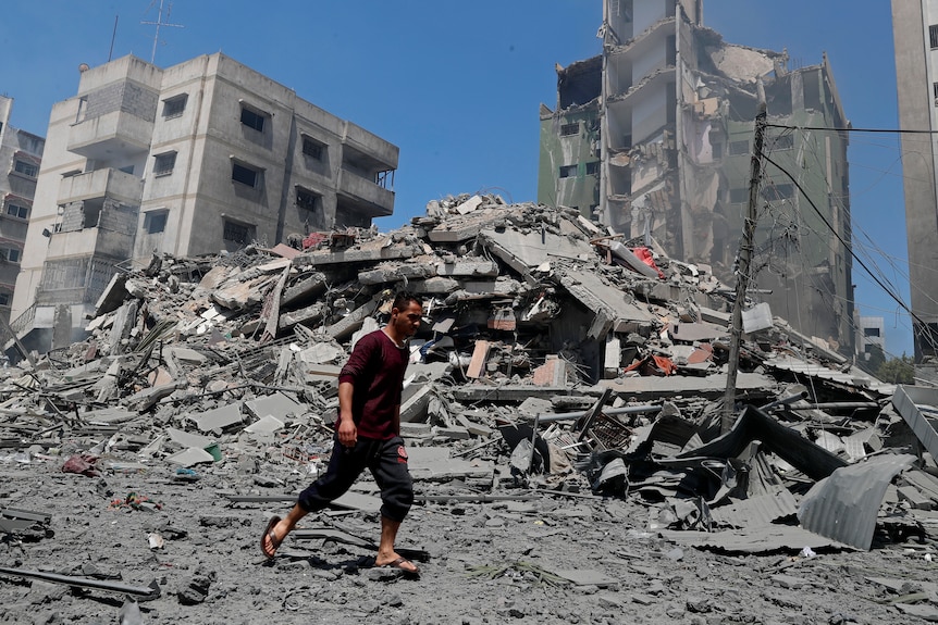 Man walks past the rubble of a destroyed building in Gaza 