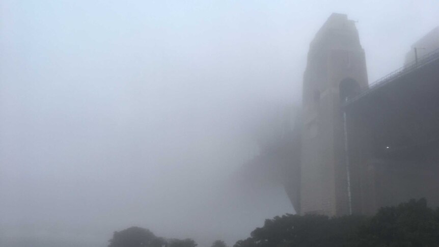 Kabut tebal menyelimuti jembatan Sydney Harbour Bridge, yang menjadi ikon kota Sydney.
