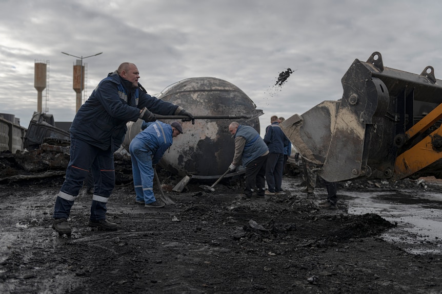 Workers clean up at a fuel depot hit by Russian missile.