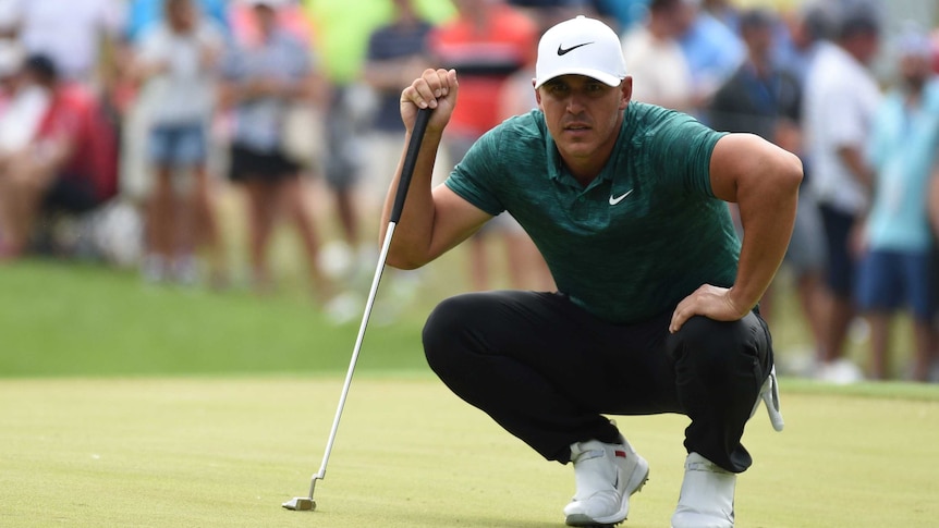 Brooks Koepka lines up a putt on the 3rd green.