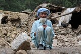 An Afghan man sits near his house that was destroyed in an earthquake