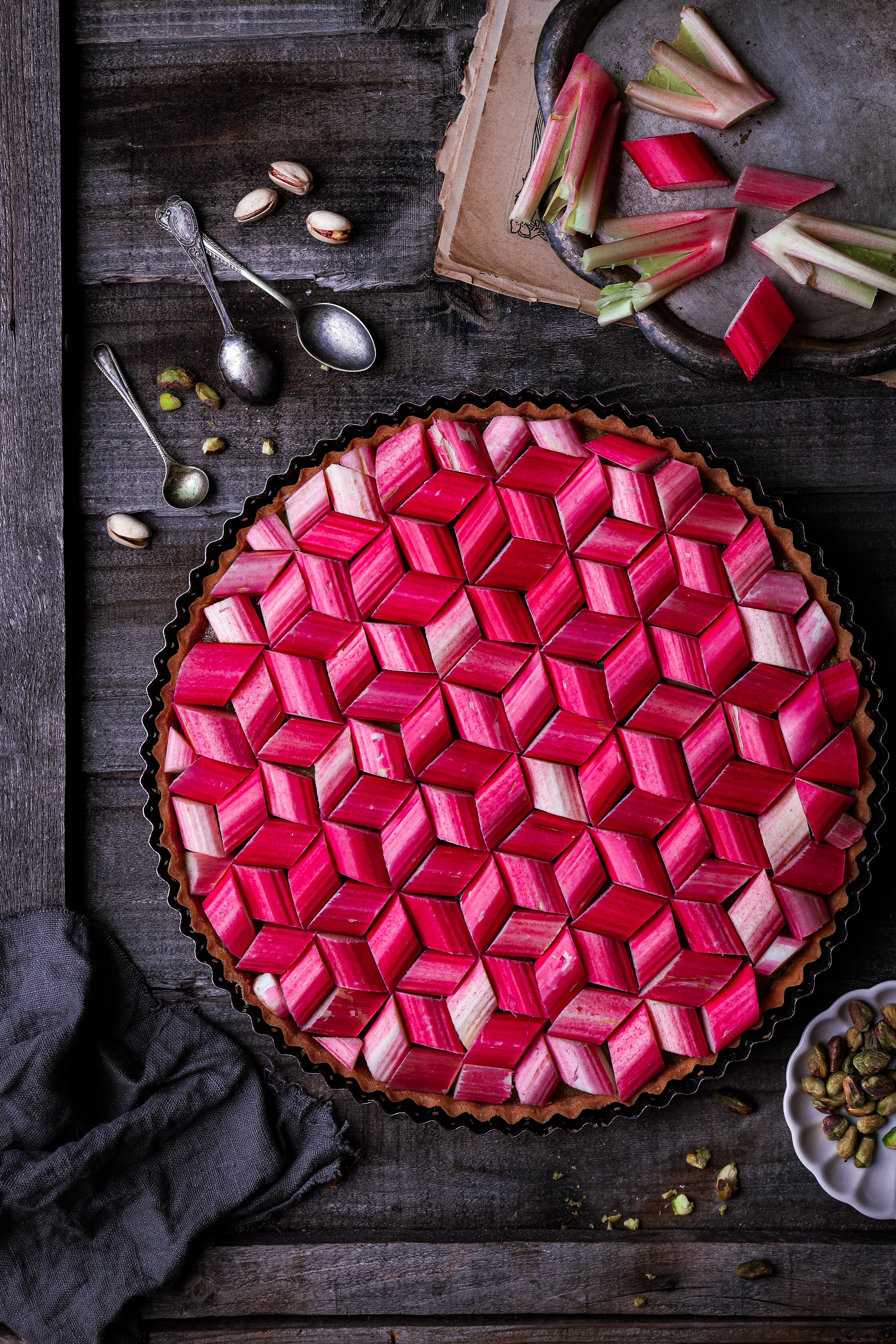 Slices of rhubarb are arranged in a geometric pattern to create the top lattice of a pie