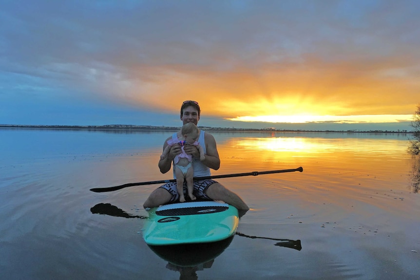 Scott Jefferis and his daughter Emmy on a paddleboard on lake Dumbleyung, that has filled after flooding in the area.