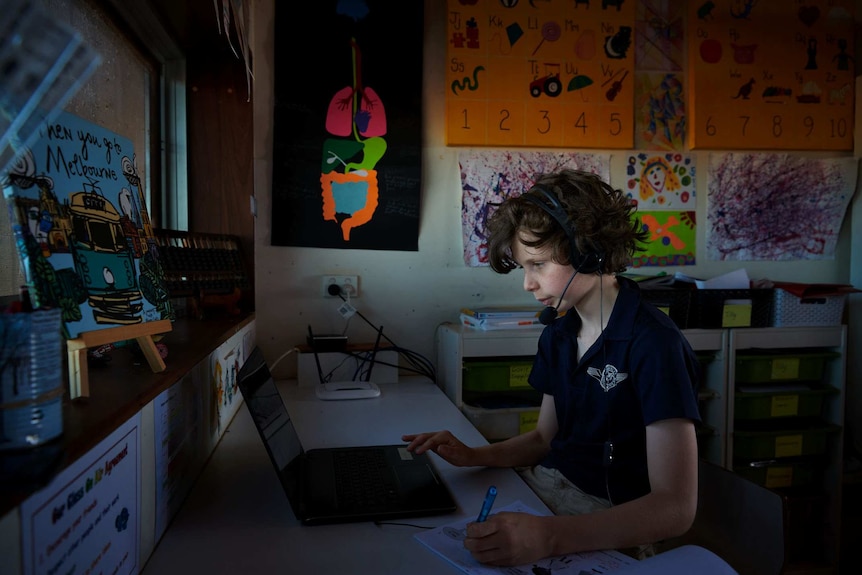 Angus Sale sits with headphones on during a School of the Air class