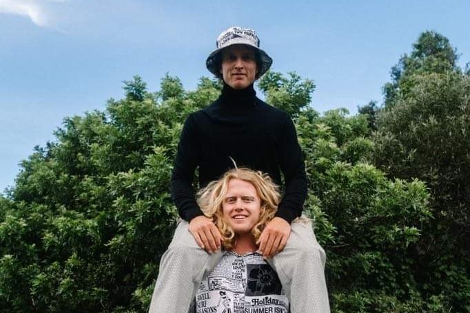 a man sitting on another man's shoulders