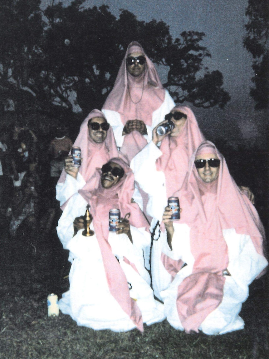 an old photo of men dressed as pink nuns