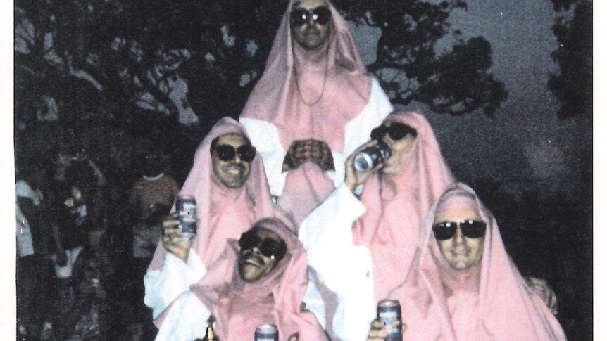 an old photo of men dressed as pink nuns