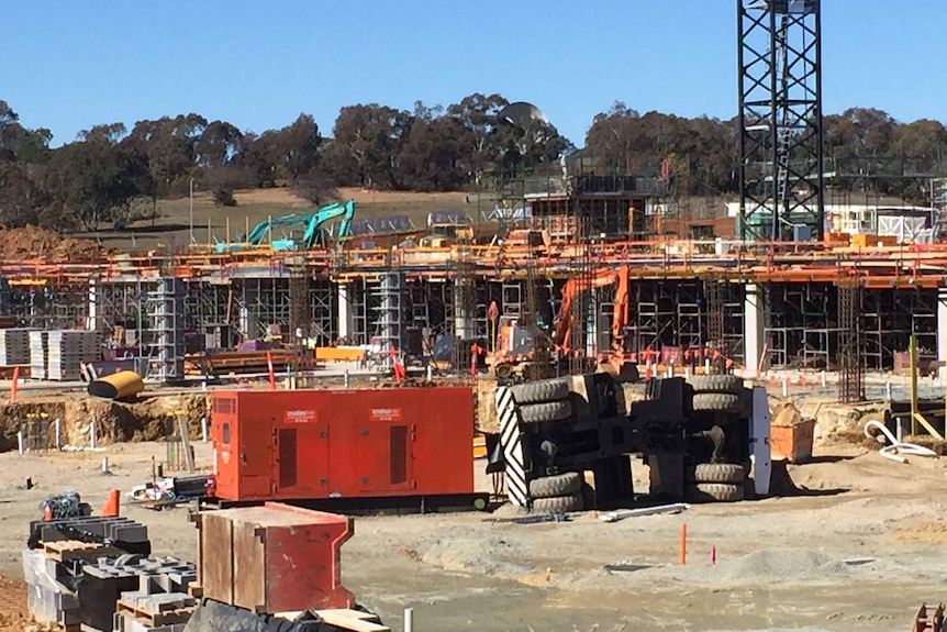 A crane on its side at the construction site.