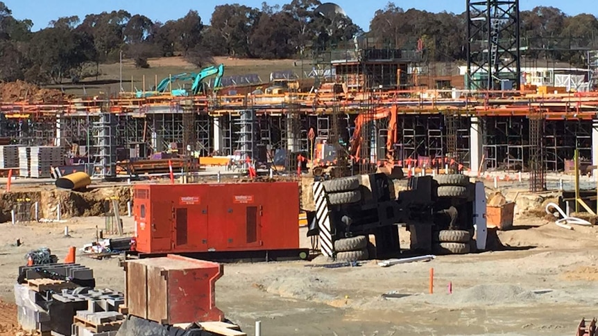 A crane on its side at the construction site.