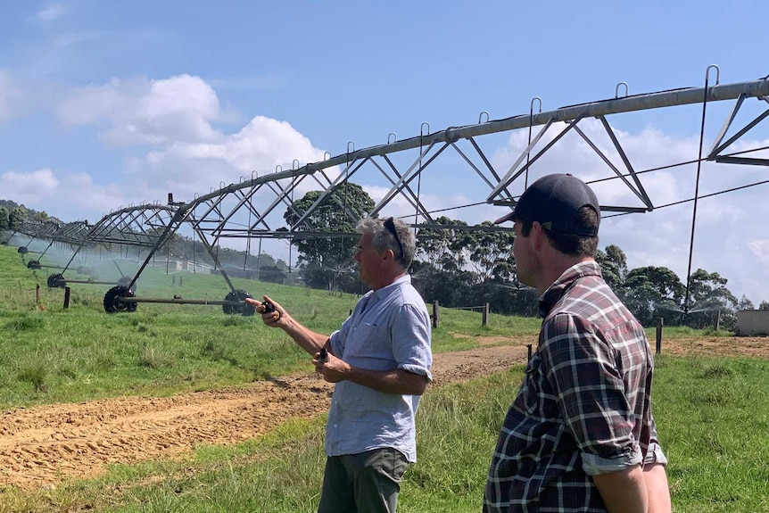 Farmer and consultant with irrigation in background.