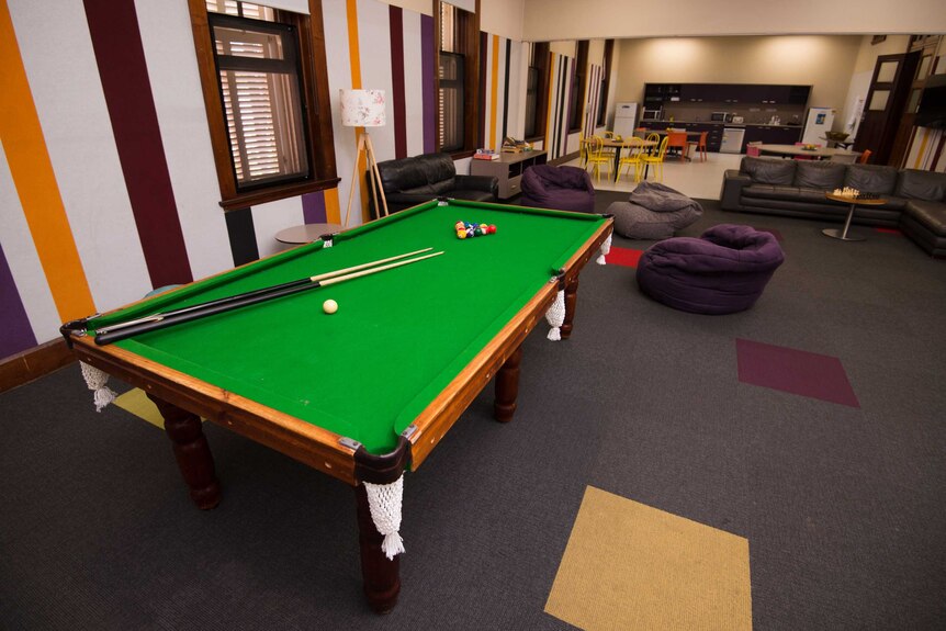An empty room with a pool table and bean bags.