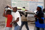 Haitians carry an injured woman in Port-au-Prince