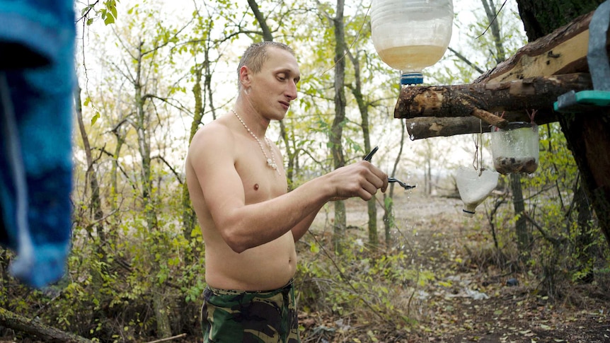 In the cold autumn morning, a Ukrainian Marine shaves at an improvised shower.