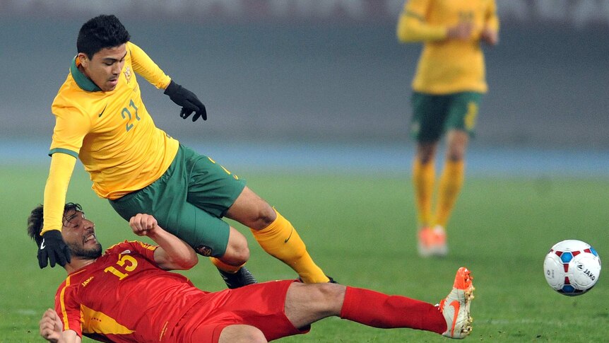 Massimo Luongo of the Socceroos is tackled