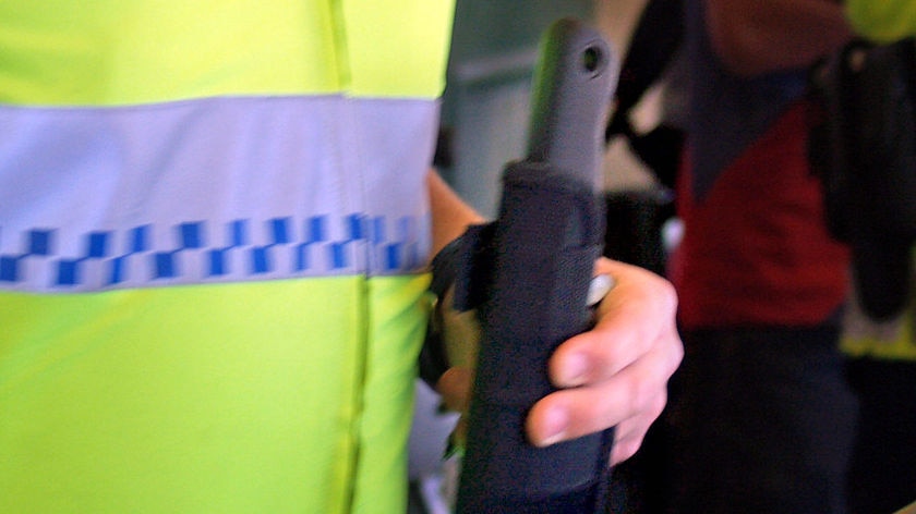 A police officer shows a machete that was confiscated from a train passenger