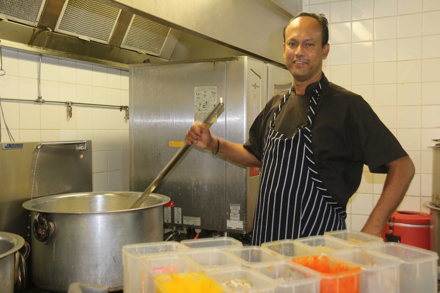 Nainar Ali stands near a big pot