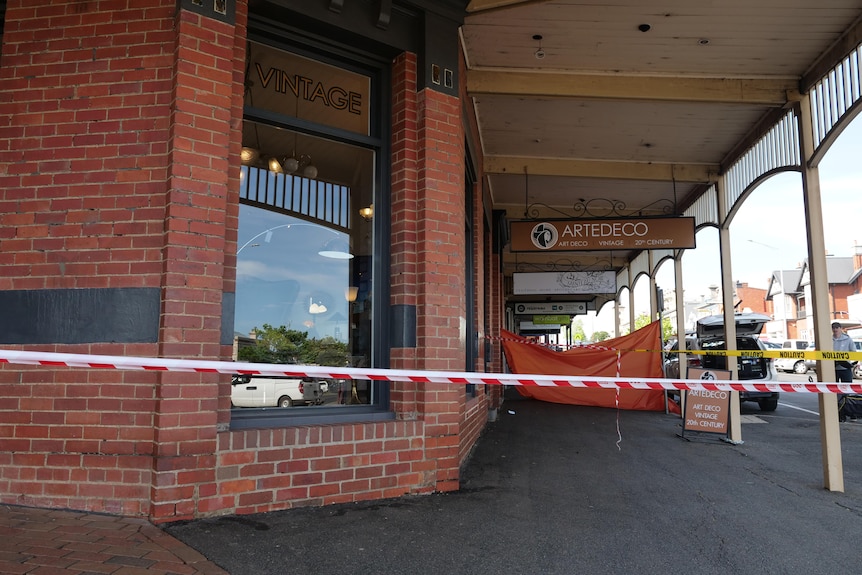 An old brick pub on the corner of a country town. The building has been cordoned off with tape.