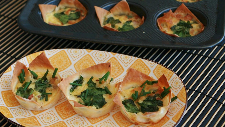 Wonton wrapper quiches on a plate and some wonton wrapper quiches in a baking tray