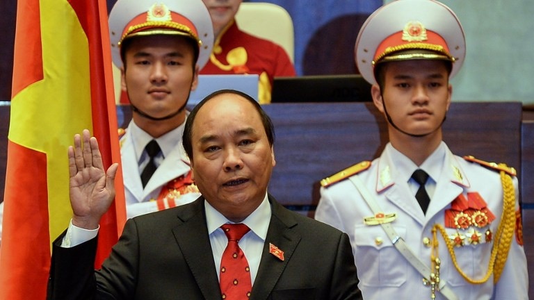 Newly elected Vietnamese Prime Minister Nguyen Xuan Phuc holds up his hand as he is sworn in during a ceremony.