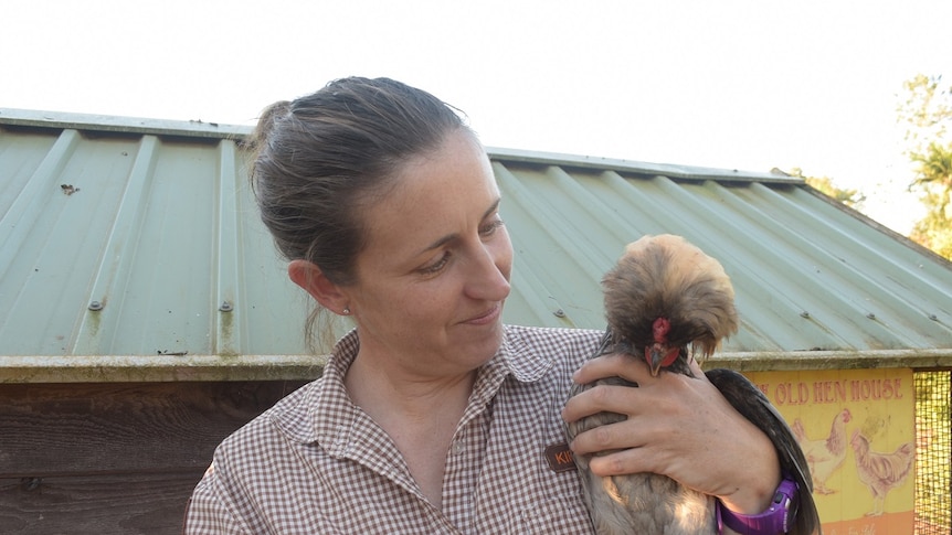 Woman holds a pet chicken