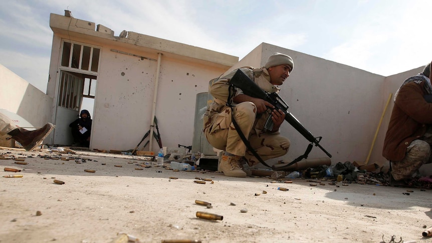 Iraqi soldiers take cover during operation against Islamic State militants.