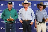 Ryan Garland, Dean Perrett and Kelly Dixon standing with their golden guitars