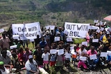 People supporting a rival mining consortium hold anti-BCL signs at the Panguna mine site.