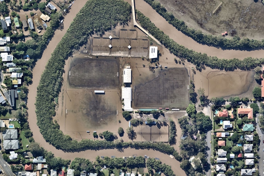 Aerial image of football fields and tennis courts almost completely covered by floodwaters.