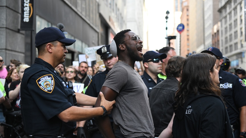 A man is arrested by police outside an Amazon store.