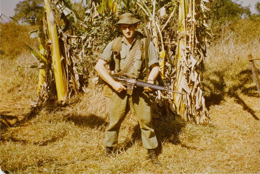John Young in Nui Dat in Vietnam in 1969 pictured with his gun and ammunition.