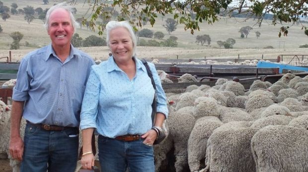 Andrew and Anne Basnett stand by a flock of sheep.