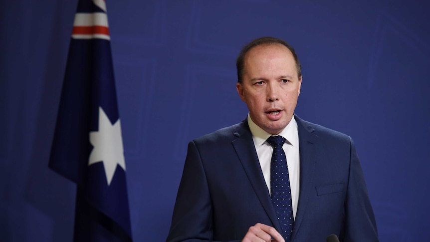 Peter Dutton speaks in front of Australian flag October 30, 2016