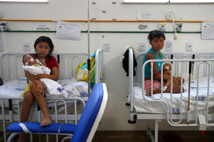 Yanomami women hold their babies while sitting on beds at the Santo Antonio Children's Hospital