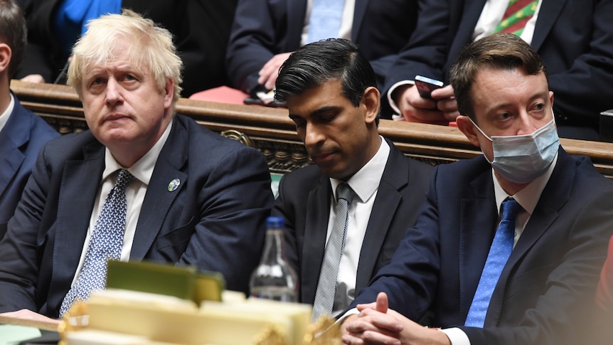Boris Johnson looks up at the ceiling as he sits next to Rishi Sunak