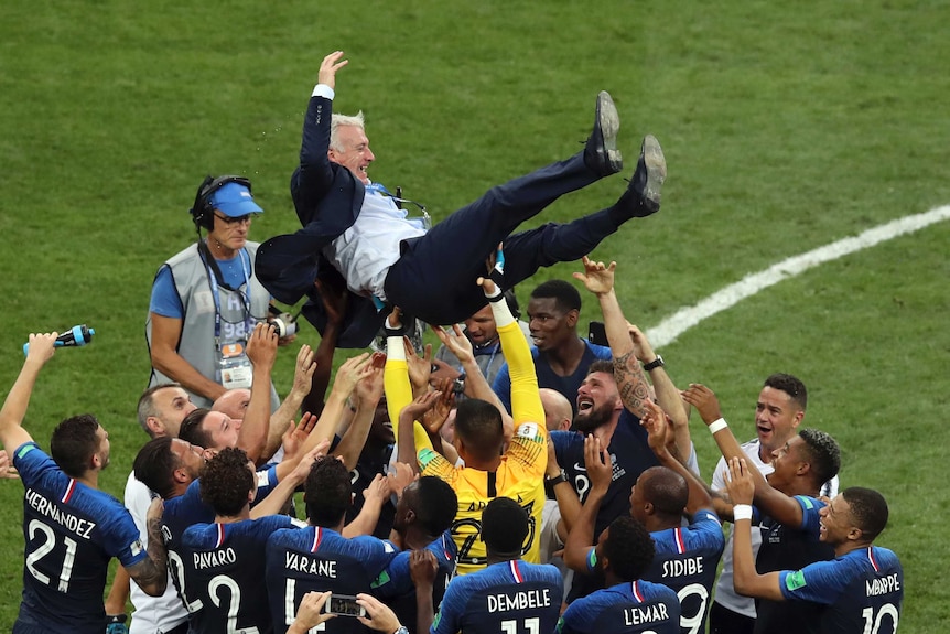 French players throw coach Didier Deschamps into the air