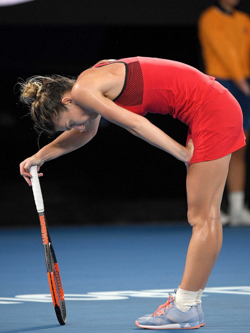 Romania's Simona Halep rests on her racquet.
