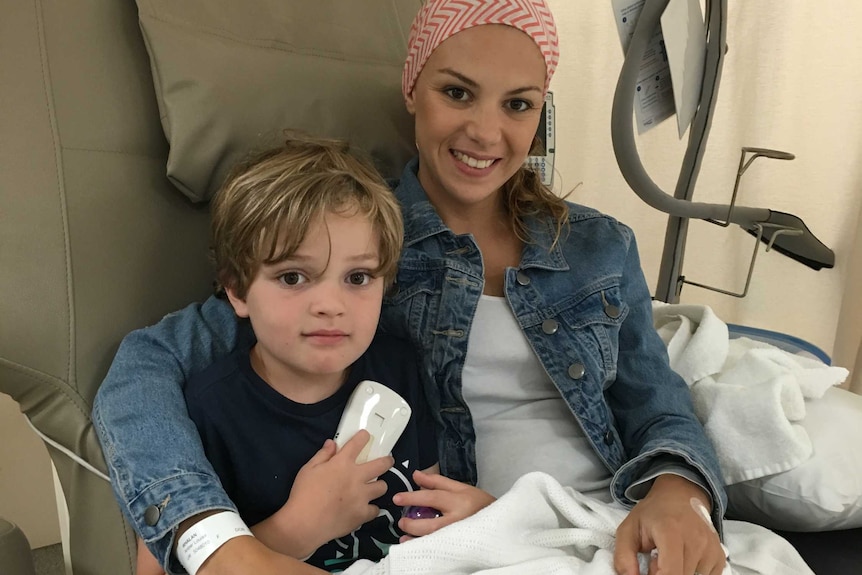 Cancer patient Amber hugs her son while undergoing treatment