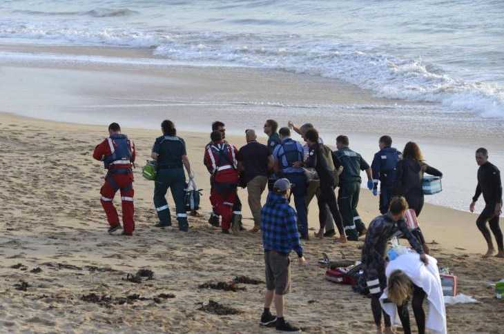 A surfer injured in a shark attack is carried from the beach on a stretcher by rescuers.