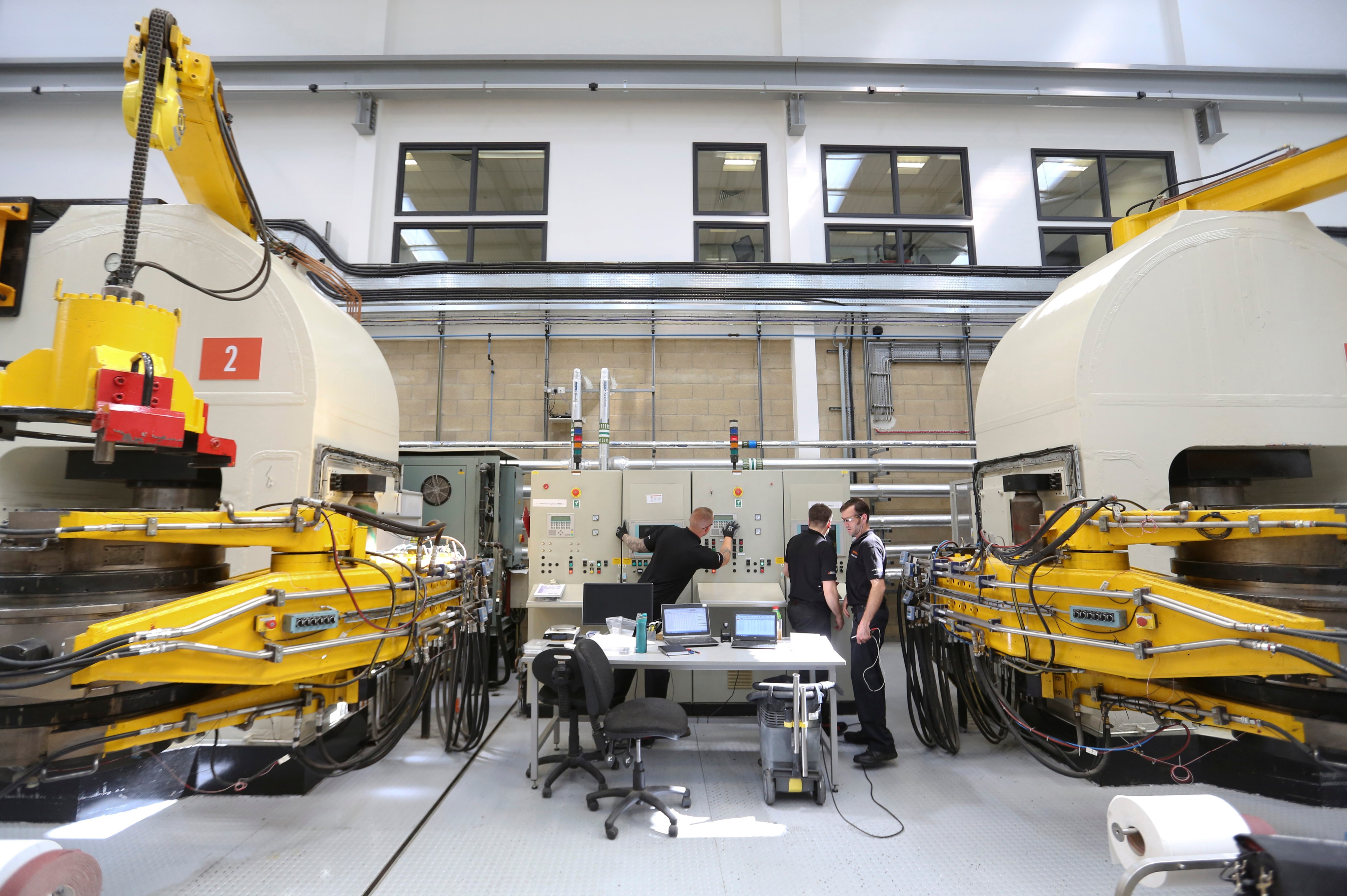 Os funcionários trabalham em prensas de correia de alta pressão e alta temperatura para produzir diamantes no laboratório da De Beers.