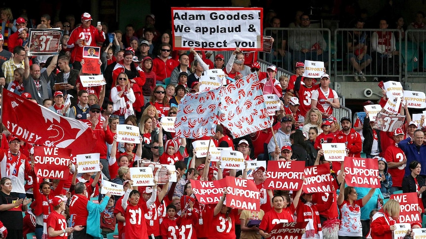Sydney Swans fans holds banners in support of Adam Goodes.
