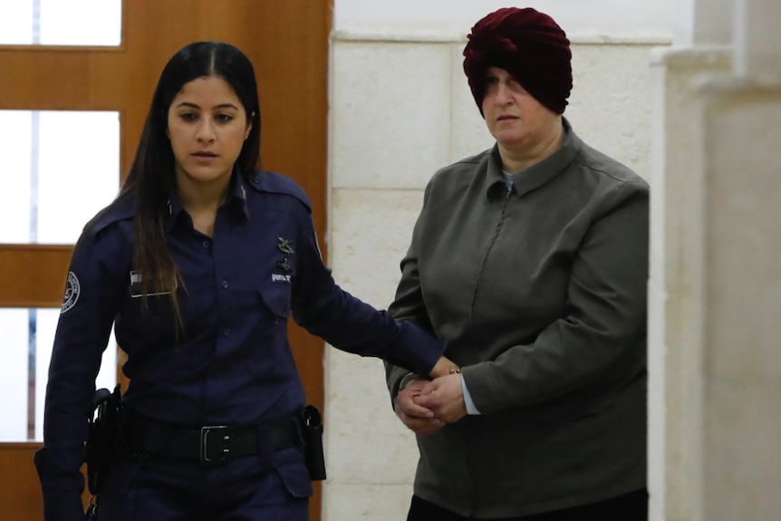Malka Leifer is led from the court by a police woman.