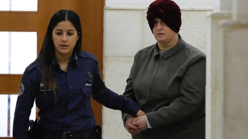 Malka Leifer is led from the court by a police woman.