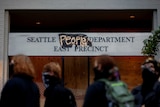 A sign reading 'Seattle People Department East Precinct" after the word 'police' was removed